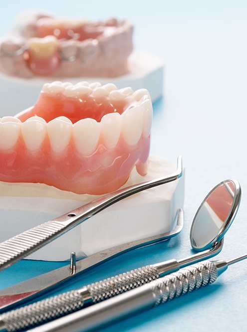 A closeup of denture models against a blue background