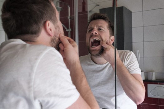 Patient checking gums in mirror