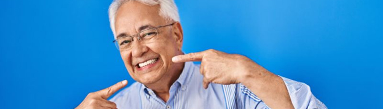 Senior man confidently pointing at his smile