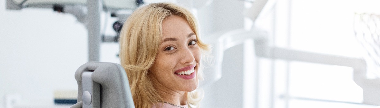 Smiling dental patient looking over her shoulder