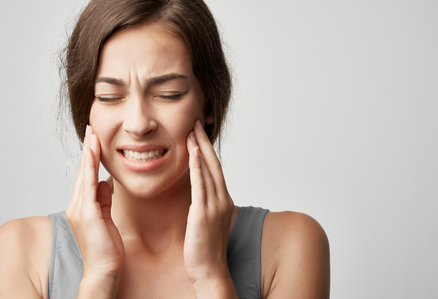 Woman holding jaw in pain
